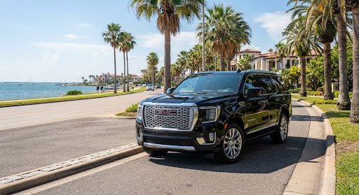Black premium SUV on a palm-lined avenue